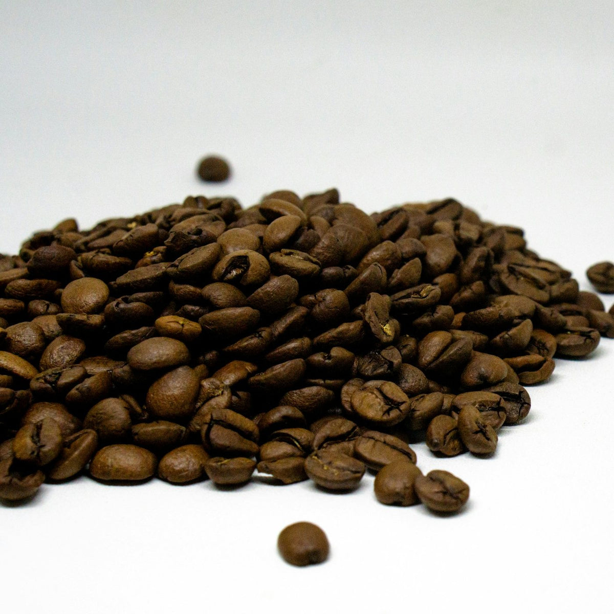 Granos de café tostado sobre un fondo blanco